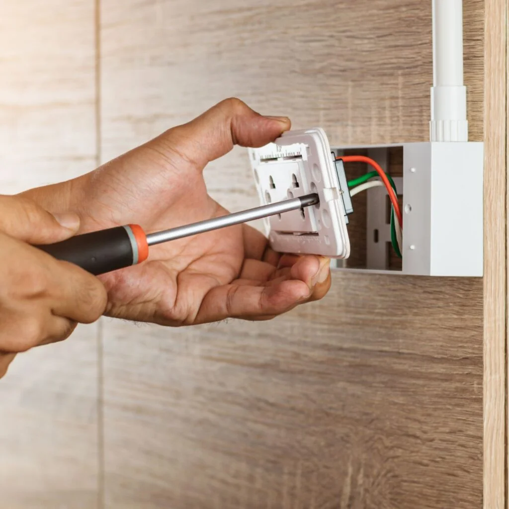 Person installing a power point into a wall